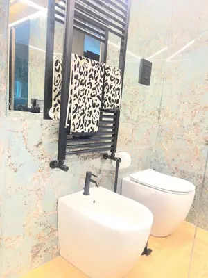 a bathroom with a sink and a chair and a toilet at SCJAVURU of HOME in Palermo