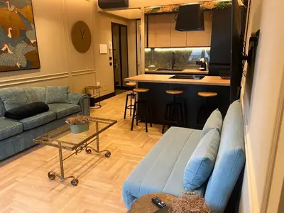 a living room with a blue couch and a kitchen at SCJAVURU of HOME in Palermo