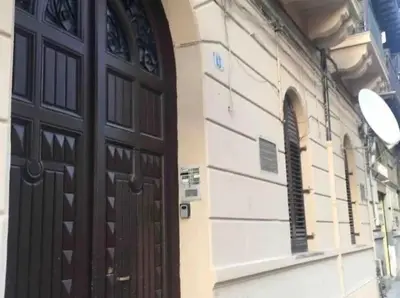 a building with a wooden door and a window at Central Station Apartaments Casa Vacanze in Palermo