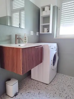 a bathroom with a sink and a washing machine at Alessandra in Alcamo