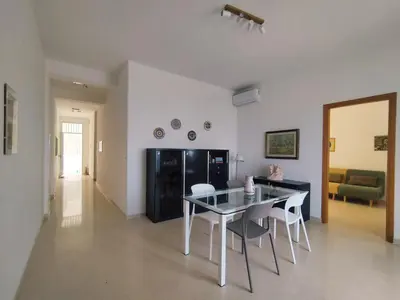 a living room with a dining table and chairs at Alessandra in Alcamo