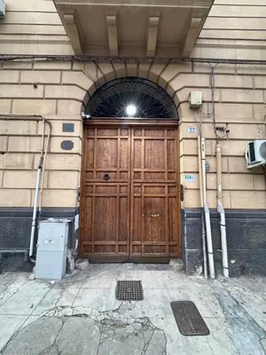 a large wooden door on a building with an arch at ÀSicilia Home Holiday in Palermo