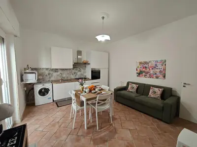 a living room with a table and a green couch at Kennedy 100 in Capaci
