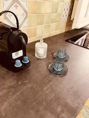a counter top with a coffee maker and cups on it at Villareale28 suite in Palermo