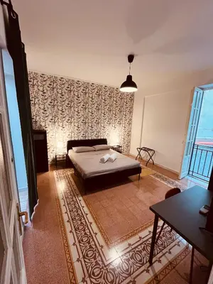 a bedroom with a bed and a large window at Villareale28 suite in Palermo