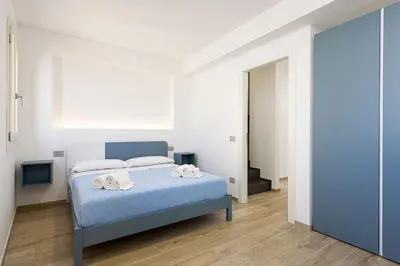 a bedroom with a blue bed with towels on it at A Casa Di Vale in San Vito lo Capo