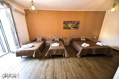 a room with three beds with towels on them at Terra Sicula Ballaroom in Palermo