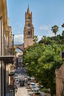 a city street with a clock tower and a tree at Apartment Papyri in Palermo
