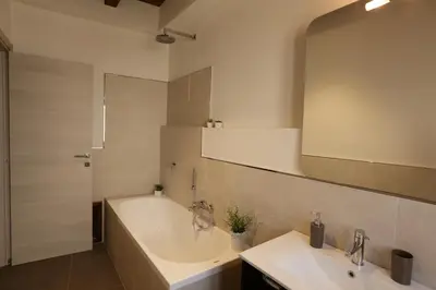 a bathroom with two sinks and a tub and a mirror at Apartment Papyri in Palermo