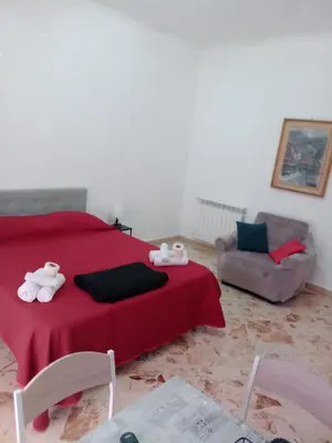 a bedroom with a red bed and a chair and a couch at Framamired in Palermo