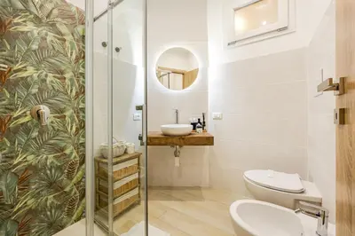 a bathroom with a toilet and a sink and a mirror at Angelica holiday home in Palermo