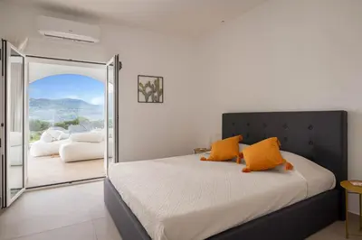 a bedroom with a large bed with orange pillows at Curina Boutique Stay - Luxury Villa in the Sicilian Countryside in Castellammare del Golfo