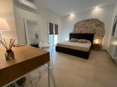 a bedroom with a bed and a stone wall at Curina Boutique Stay - Luxury Villa in the Sicilian Countryside in Castellammare del Golfo
