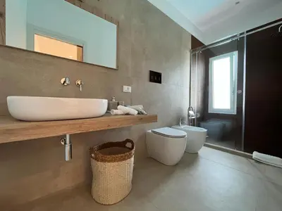 a bathroom with a sink and a toilet and a mirror at Curina Boutique Stay - Luxury Villa in the Sicilian Countryside in Castellammare del Golfo