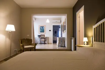 a bedroom with a bed and a living room at White and Sea Villa fronte mare a Mondello Addaura in Palermo