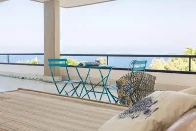 a room with a balcony with a table and chairs at White and Sea Villa fronte mare a Mondello Addaura in Palermo