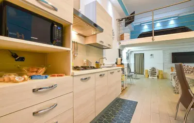 a kitchen with wooden cabinets and a microwave at Casa Toledo in Partinico