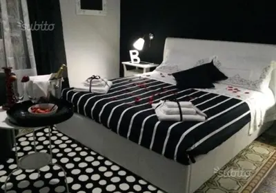 a bedroom with a large bed with black and white stripes at Alba Camere in Palermo