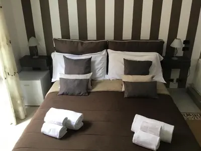 a large bed with pillows and towels on it at Alba Camere in Palermo
