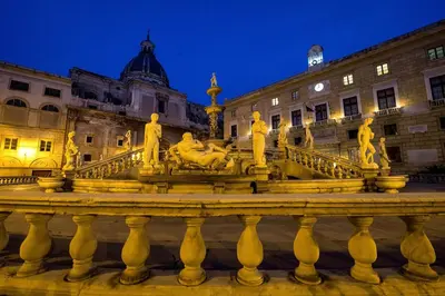 a fountain in front of a building at night at Quattro Canti Apartments in Palermo
