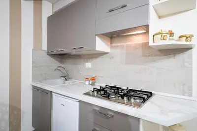 a white kitchen with a stove and a sink at Quattro Canti Apartments in Palermo