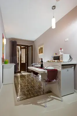 a kitchen with a table and chairs and a microwave at Via Nuova in Castellammare del Golfo