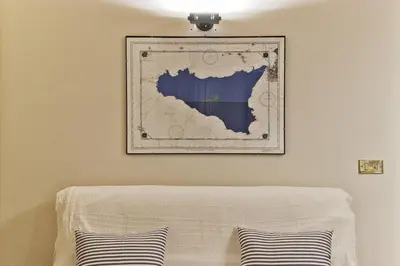 a picture hanging on a wall above a bed at Trilocale al Politeama - Zyz in Palermo