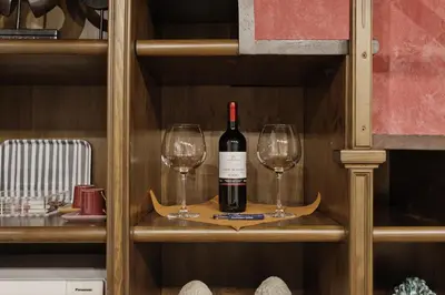 a bottle of wine and two wine glasses on a shelf at Trilocale al Politeama - Zyz in Palermo