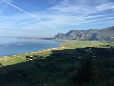 a view of a beach with mountains in the background at Baglio Fontana in Castelluzzo