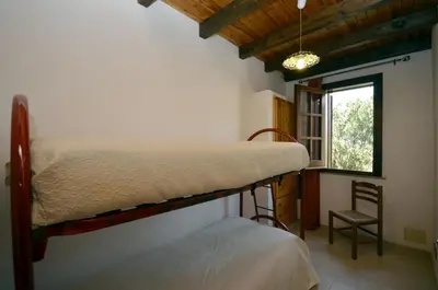 a bedroom with a bunk bed and a chair at Baglio Fontana in Castelluzzo