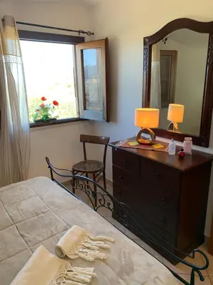 a bedroom with a bed and a dresser and a mirror at Casa Eva in Castelluzzo