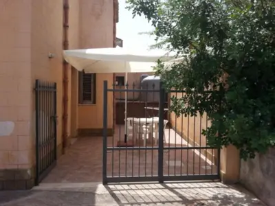 a gate in a building with an umbrella at Casa Eva in Castelluzzo