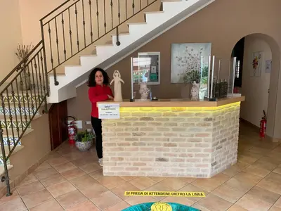 a woman standing at a counter in a house at Cala di Ponente in Castelluzzo