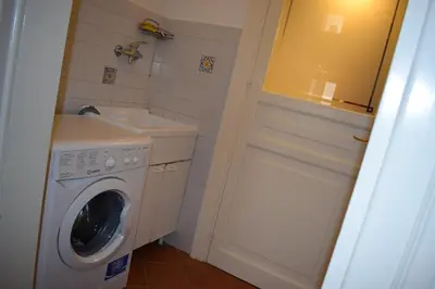 a small bathroom with a washing machine and a sink at I Pupi Di Belfiore in Palermo
