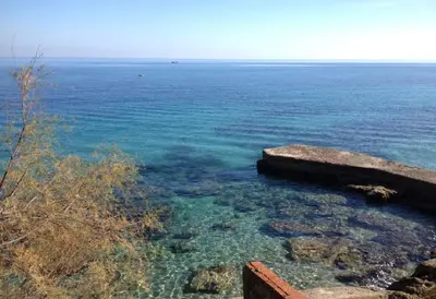a view of the ocean with rocks and water at Villa Agave - SeaFront - Pool Kids - BBQ in Santa Flavia