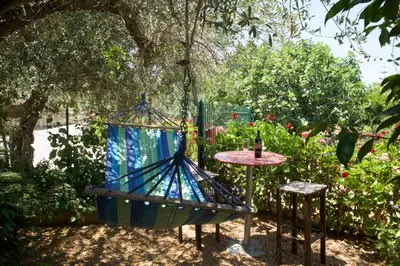 a stained glass swing in a garden with a table at Casa Vacanza e Camera Fabiola in Castellammare del Golfo