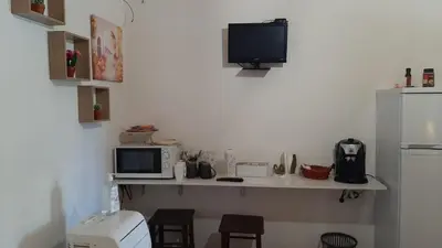 a kitchen with a counter with a microwave and a tv at Casa Vacanza e Camera Fabiola in Castellammare del Golfo