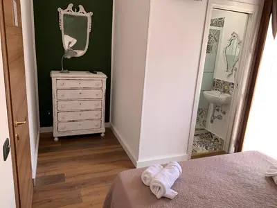 a room with a bed and a sink and a mirror at Cialoma B&B in Palermo