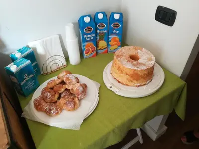 a table with a plate of donuts and a cake at Cialoma B&B in Palermo