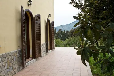 a building with brown shuttered windows and a walkway at Agriturismo Rajata in Bagheria