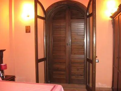 a wooden door in a room with a bed at Agriturismo Rajata in Bagheria