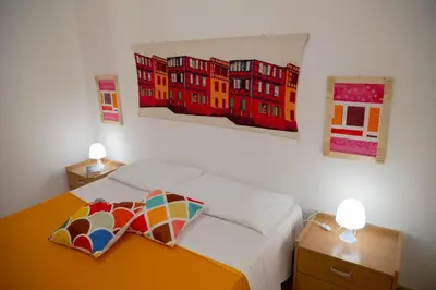 a bedroom with a bed with two paintings on the wall at Villa Maria in San Vito lo Capo