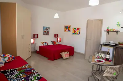 a bedroom with a bed with a red blanket at Villa Maria in San Vito lo Capo