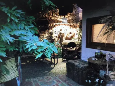 a living room with a stone wall and plants at Villa Il Cappero in San Vito lo Capo