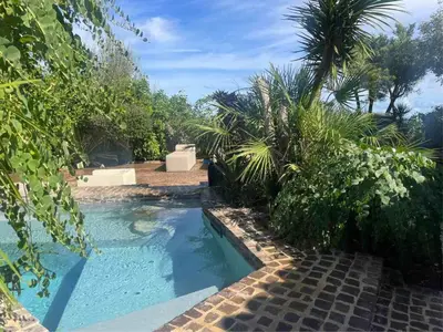 a swimming pool in a garden with palm trees at Villa Il Cappero in San Vito lo Capo