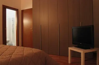 a bedroom with a bed and a television on a table at La Casetta in Palermo