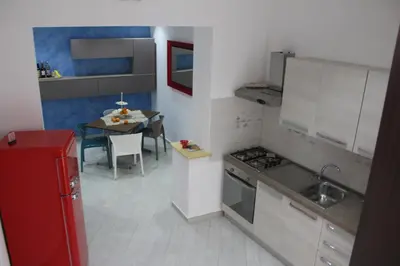 a small kitchen with a table and a red refrigerator at B&B Xenia in Palermo