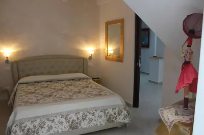 a bedroom with a bed and a mirror on the wall at B&B Xenia in Palermo