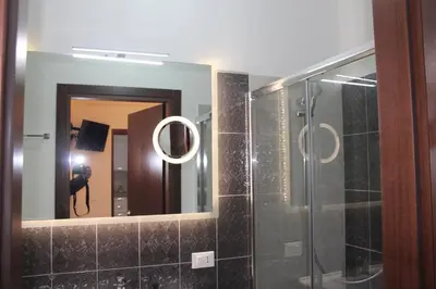 a bathroom with a shower and a mirror at B&B Xenia in Palermo