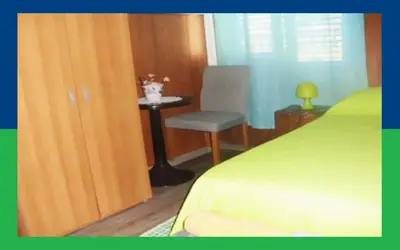 a small green bed in a room with a table at Santa Oliva Homestay in Palermo
